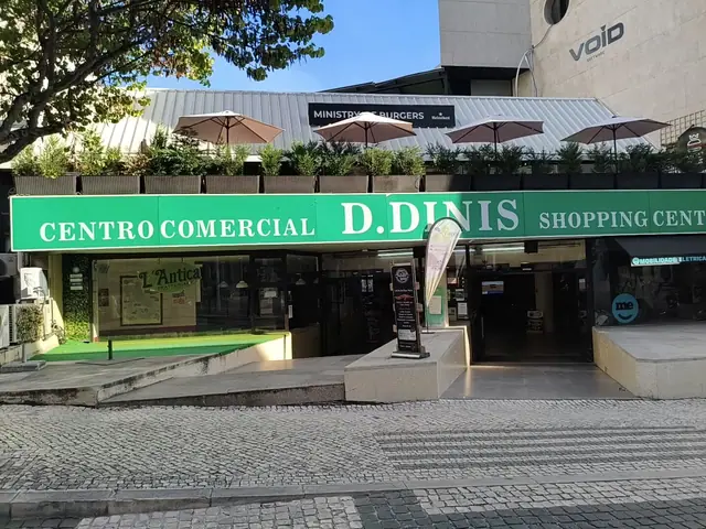 Entrada do Centro Comercial D. Dinis, em Leiria, com o letreiro verde e o painel da Docemania à porta