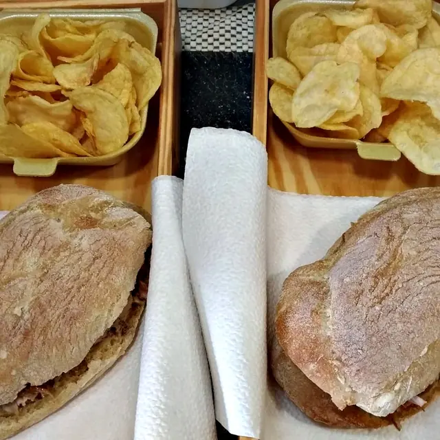 Duas sandes de leitão com batatas fritas, vistas de cima